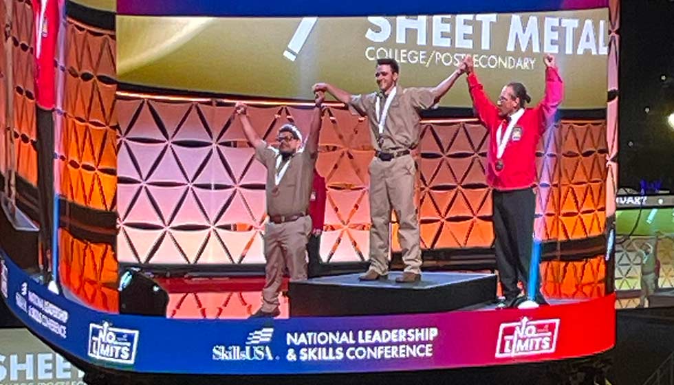 Video scoreboard with students on a medal podium, text: Sheet Metal - SkillsUSA National Leadership and Skills Conference - No limits