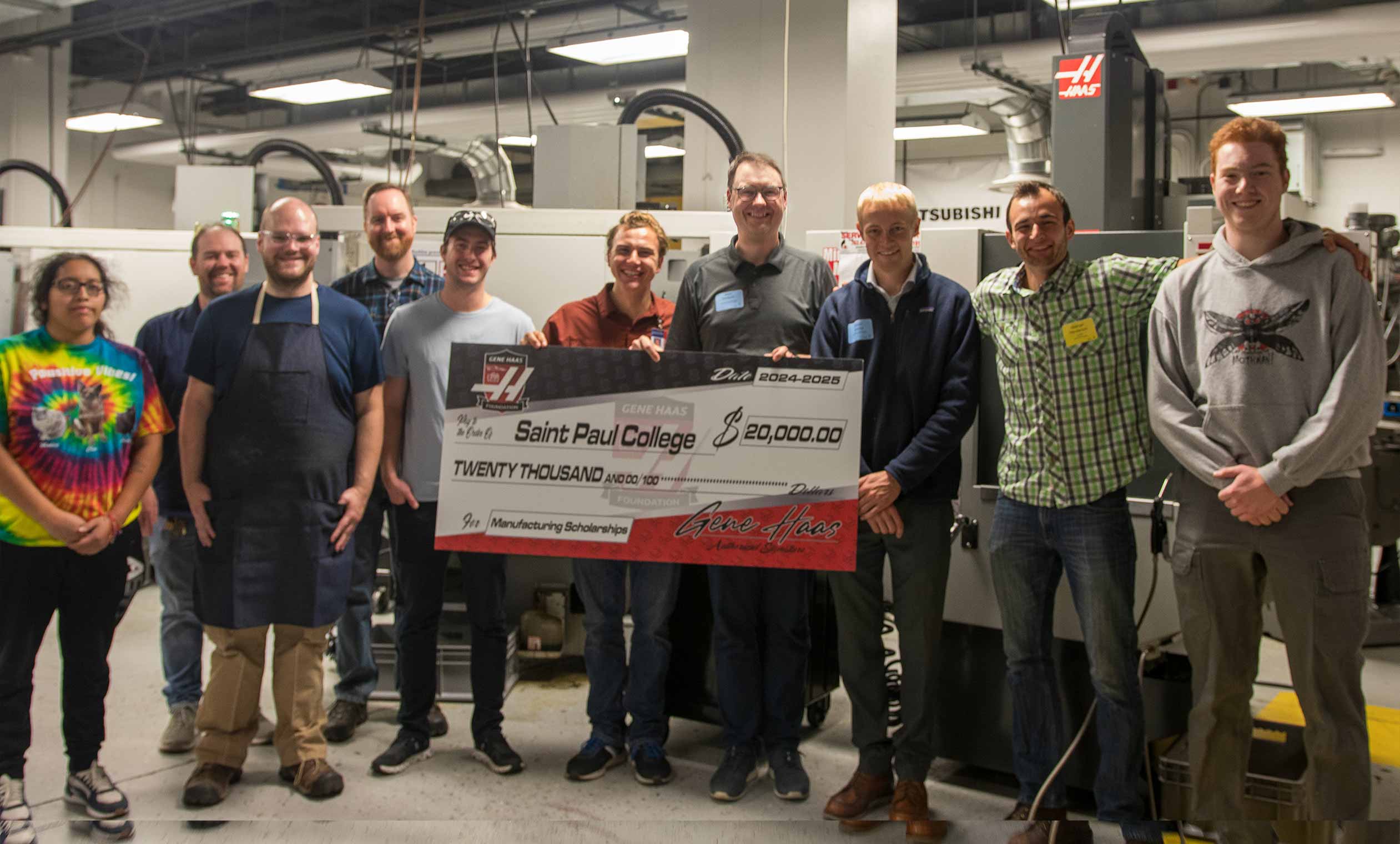 CNC students and faculty with representative from the Gene Haas foundation presenting a large check for $20,000 in the CNC lab