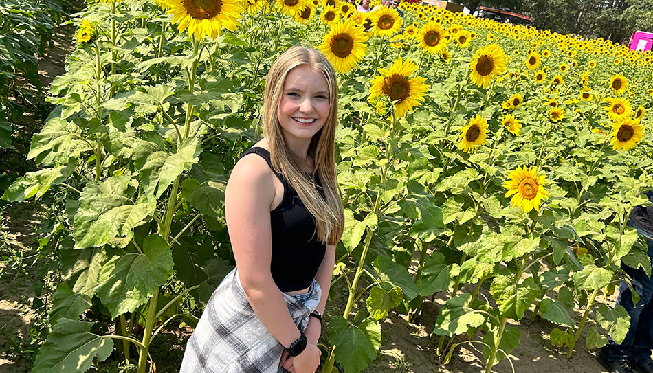 Shay Baecker in front of flowers