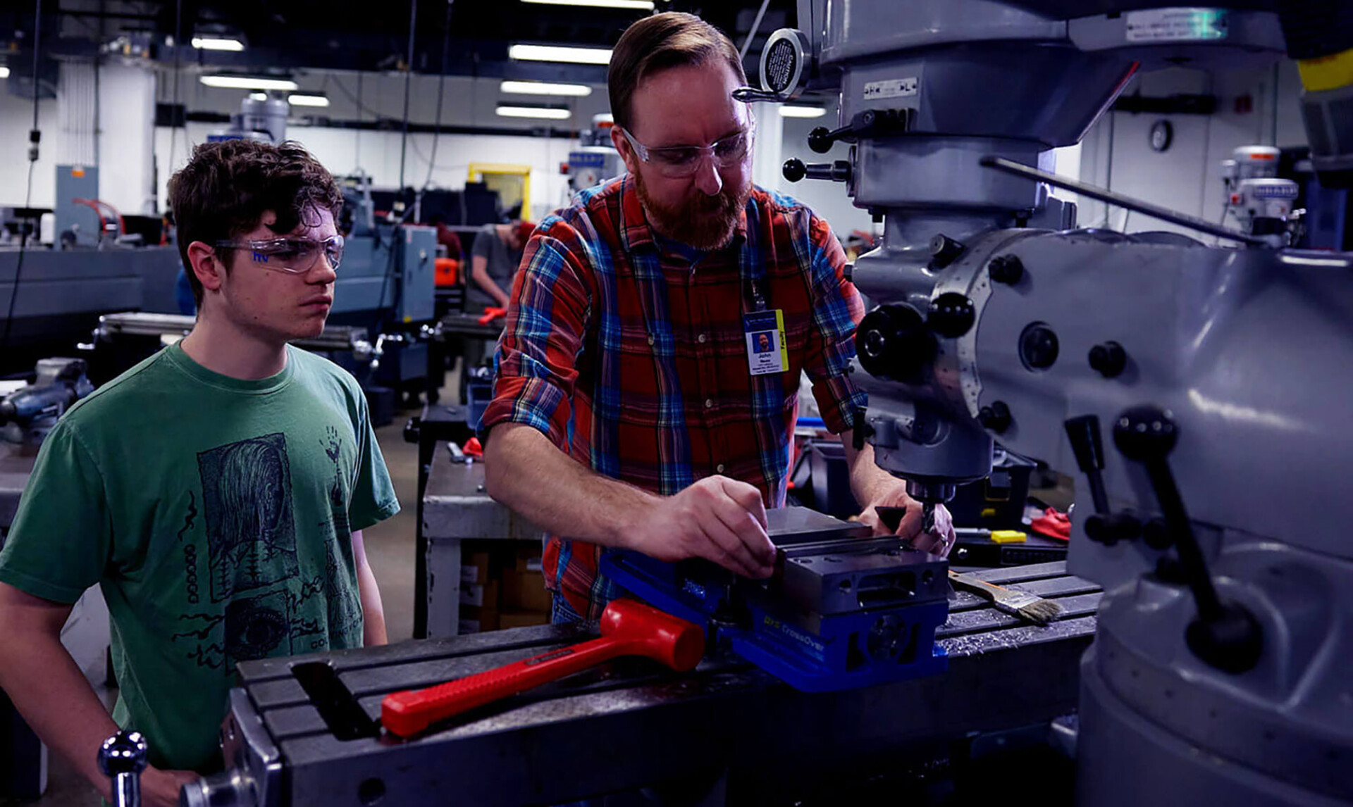 Student working with instructor in CNC lab